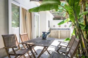 a patio with a table and chairs and a plant at La rosa dei venti in Procida