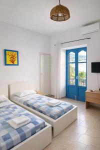 a bedroom with two beds and a blue door at Aeolian Apartments in Lipari +11 photos