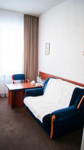 a hotel room with a bed and a table and chairs at Zajazd Przy Granicy in Słuczanka +5 photos