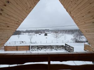 a view of a snow covered field with benches at Cabana Alisa Sapanta in Săpânța