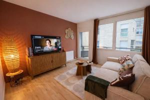 a living room with a couch and a flat screen tv at Appartement hyper Centre Rénové Terrasse & Parking in Tours