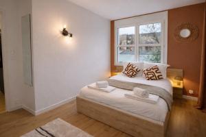 a bedroom with a bed with pillows and a window at Appartement hyper Centre Rénové Terrasse & Parking in Tours