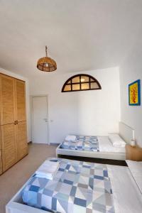 a bedroom with two beds and a window at Aeolian Apartments in Lipari