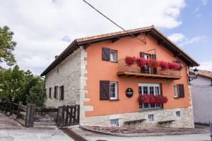 a house with flower boxes on the side of it at Mendiburu Rural Boutique in Osinaga