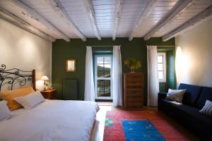 a bedroom with a bed and a couch and a window at Mendiburu Rural Boutique in Osinaga