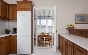 a kitchen with a refrigerator and a table with chairs at Seashore Villas Tinos in Tinos +116 photos