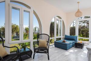 a living room with windows and a blue couch at Seashore Villas Tinos in Tinos