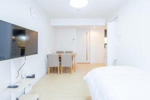 a white room with a bed and a dining room at mks102 in Sapporo