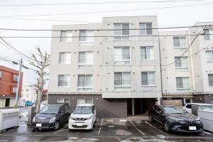 two cars parked in a parking lot in front of a building at mks102 in Sapporo