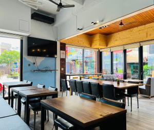 a restaurant with wooden tables and chairs and windows at Stay Hotel in Xiaoliuqiu