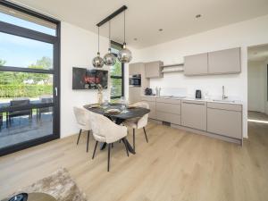 a kitchen with a dining room table and chairs at Villa Meerzicht | 4 Pers. in Workum