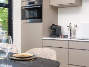 a kitchen with a table with chairs and a microwave at Villa Meerzicht | 4 Pers. in Workum