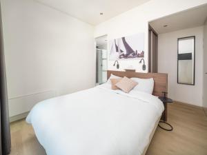a bedroom with a large white bed and a mirror at Villa Meerzicht | 4 Pers. in Workum +12 photos