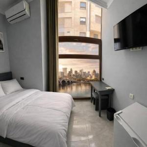 a bedroom with a window with a view of a city at Republic Square In Hotel California in Yerevan