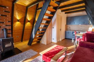 a living room with a staircase and a kitchen at Golden Cabins Gjinar by PikHost in Elbasan