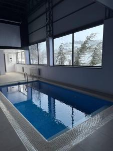 a swimming pool with blue water in a building at Green Veranda in Nurekata