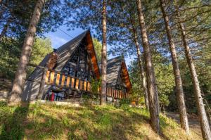 a wooden house in the woods with trees at Golden Cabins Gjinar by PikHost in Elbasan