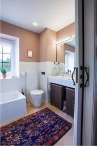 a bathroom with a tub and a toilet and a sink at Mendiburu Rural Boutique in Osinaga +36 photos