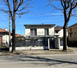 a white house with a balcony on the side of a street at B&b cuore di casa in Ferno +1 photo