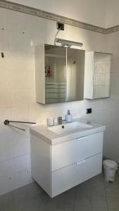 a white bathroom with a sink and a mirror at B&b cuore di casa in Ferno