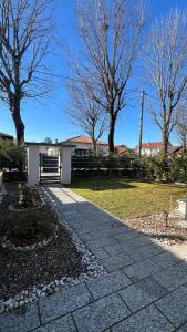 a walkway in front of a house with trees at B&b cuore di casa in Ferno