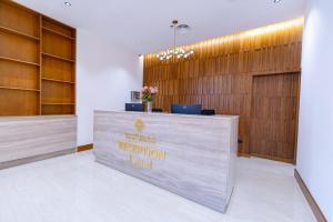 a reception desk with a sign on it in a lobby at Jasmine Garden Makkah in Al Masfalah