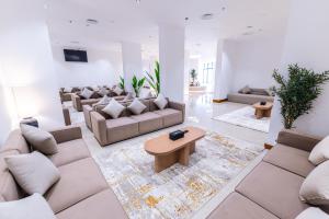 a living room with couches and a table at Jasmine Garden Makkah in Al Masfalah