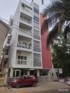a red car parked in front of a building at Elegant 2 BHK Furnished flat without AC and with AC additional price in Belgaum