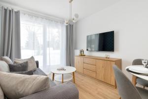 a living room with a couch and a tv at Pino Resort Gdańsk by Solarento in Gdańsk +15 photos