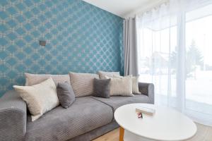 a living room with a couch and a table at Pino Resort Gdańsk by Solarento in Gdańsk