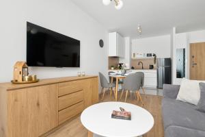 a living room with a couch and a table at Pino Resort Gdańsk by Solarento in Gdańsk