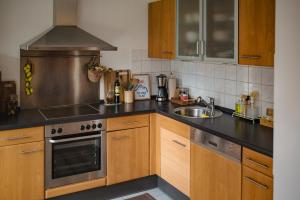a kitchen with wooden cabinets and a stove top oven at Helle Wohnung in Seenähe in Berg am Starnberger See
