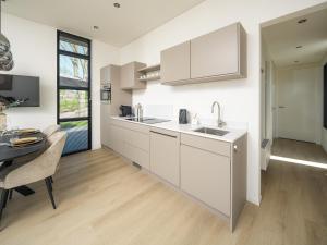 a kitchen with white cabinets and a dining table at Villa Meerzicht | 6 Pers. in Workum