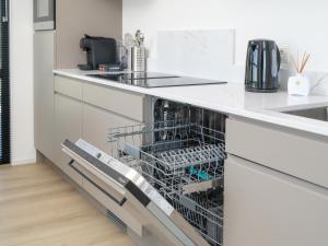 a dishwasher in a kitchen with white counters at Villa Meerzicht | 6 Pers. in Workum