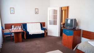 a room with a tv and a chair and a table at Zajazd Przy Granicy in Słuczanka