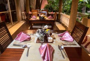 a table with pink napkins and utensils at a restaurant at Comfort Gardens in Nairobi