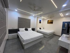 a bedroom with two beds in a room at Hotel Tulsi in Aurangabad +5 photos