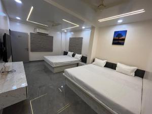 a room with two beds and a television in it at Hotel Tulsi in Aurangabad