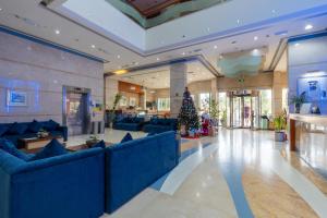 a lobby with blue couches and a christmas tree at Lavender Hotel Sharjah in Sharjah +60 photos