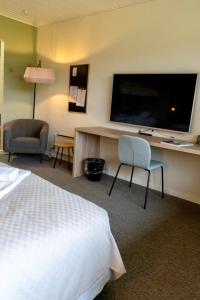 ein Hotelzimmer mit Bett und Flachbildfernseher in der Unterkunft Strandhotel Klitrosen in Fjerritslev