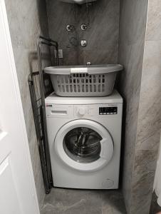 a washing machine with a basket on top of it at Little Village Loft in Káty