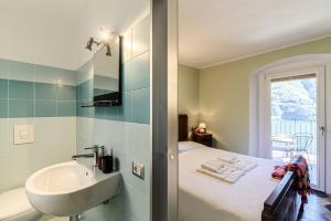 a bathroom with a sink and a bed with a window at Albergo Diffuso Ca' Spiga in Laglio +276 photos