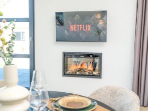a fireplace in a dining room with a tv at Villa L-Meerzicht | 4 pers. in Workum +13 photos