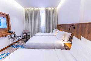 a hotel room with two beds and a flat screen tv at Jasmine Garden Makkah in Al Masfalah +26 photos