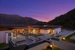 an aerial view of a house with mountains in the background at Taj Paro Resort & Spa in Paro