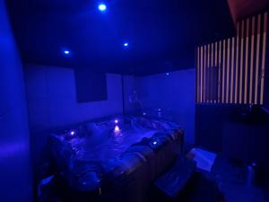 a room with a tub with blue lights in it at Love room Jacuzzi - Litchi in Bordeaux