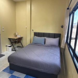 a large bed in a room with a window at O Pha Suk House in Hat Yai