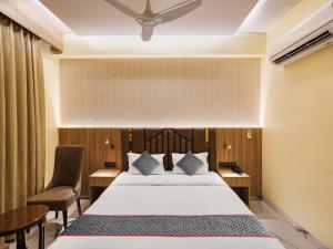 a hotel room with a bed and two chairs at Hotel Asian Near Delhi Airport in New Delhi