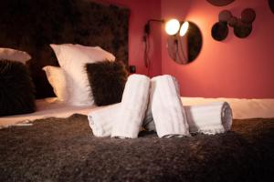 a room with two beds with white towels on them at Love room Jacuzzi - Litchi in Bordeaux