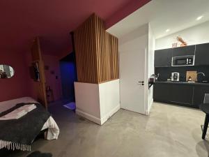 a bedroom with a bed and a purple wall at Love room Jacuzzi - Litchi in Bordeaux